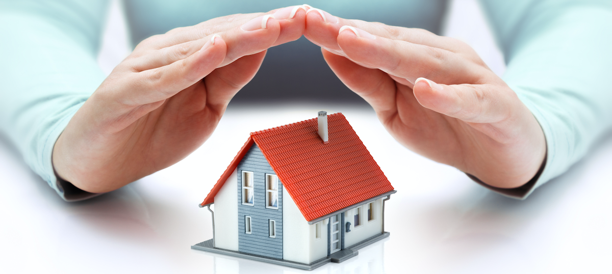 photo of hands protecting a house with homeowners insurance